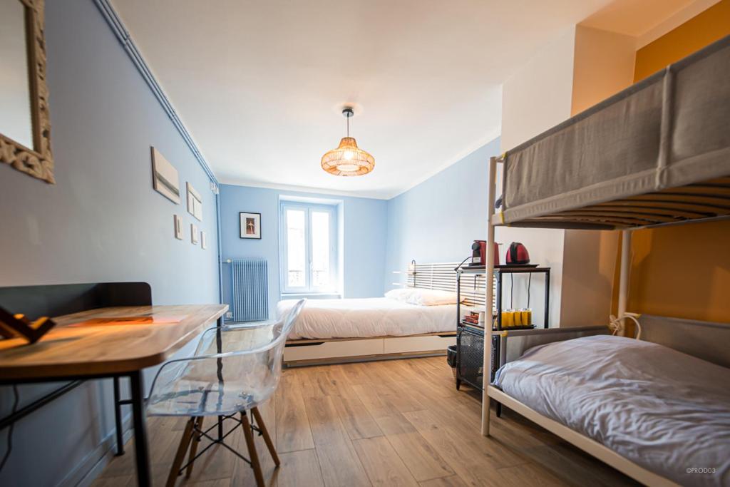 a bedroom with two bunk beds and a desk at Chambres d'hôtes du Bistrot d'ici in Saint-Saturnin