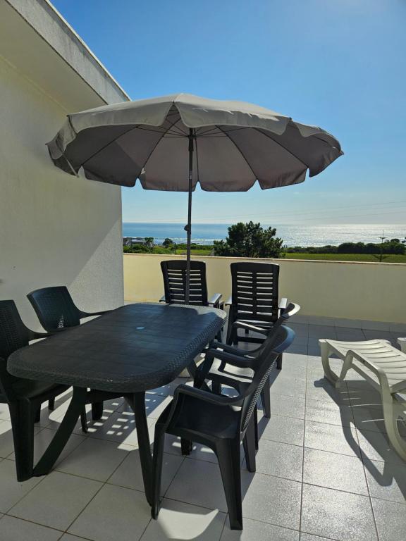 a black table and chairs with an umbrella on a patio at Residencias Ana Carmen in Viana do Castelo