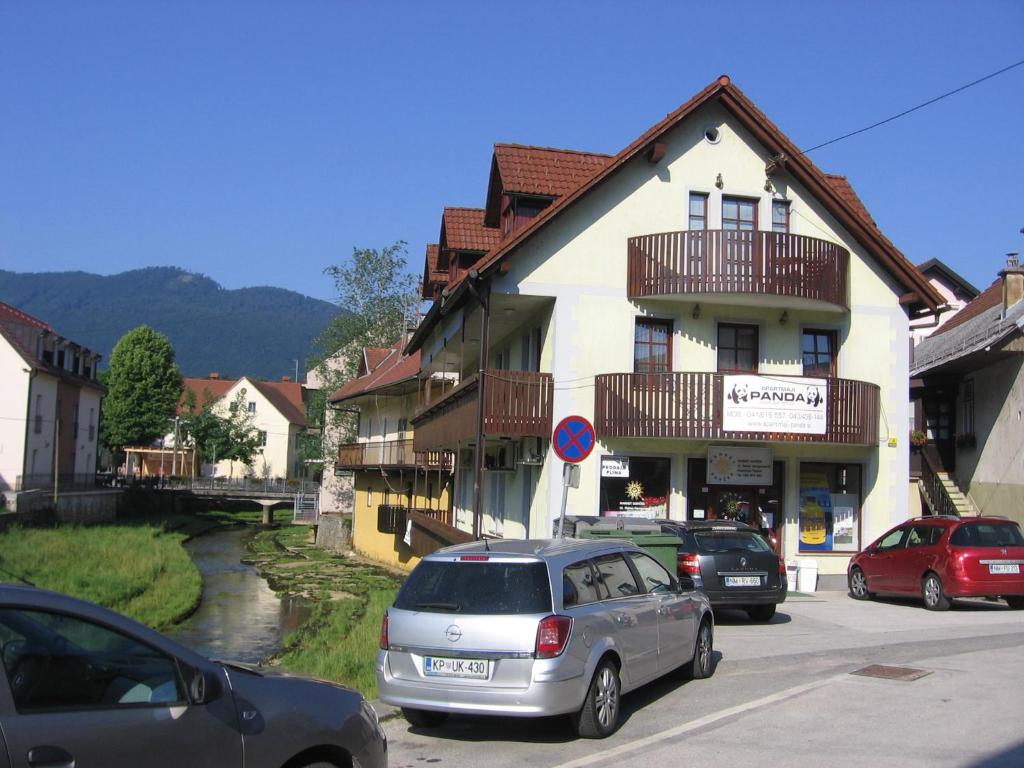 eine Gruppe von Autos, die vor einem Gebäude geparkt sind in der Unterkunft Apartment Panda in Dolenjske Toplice