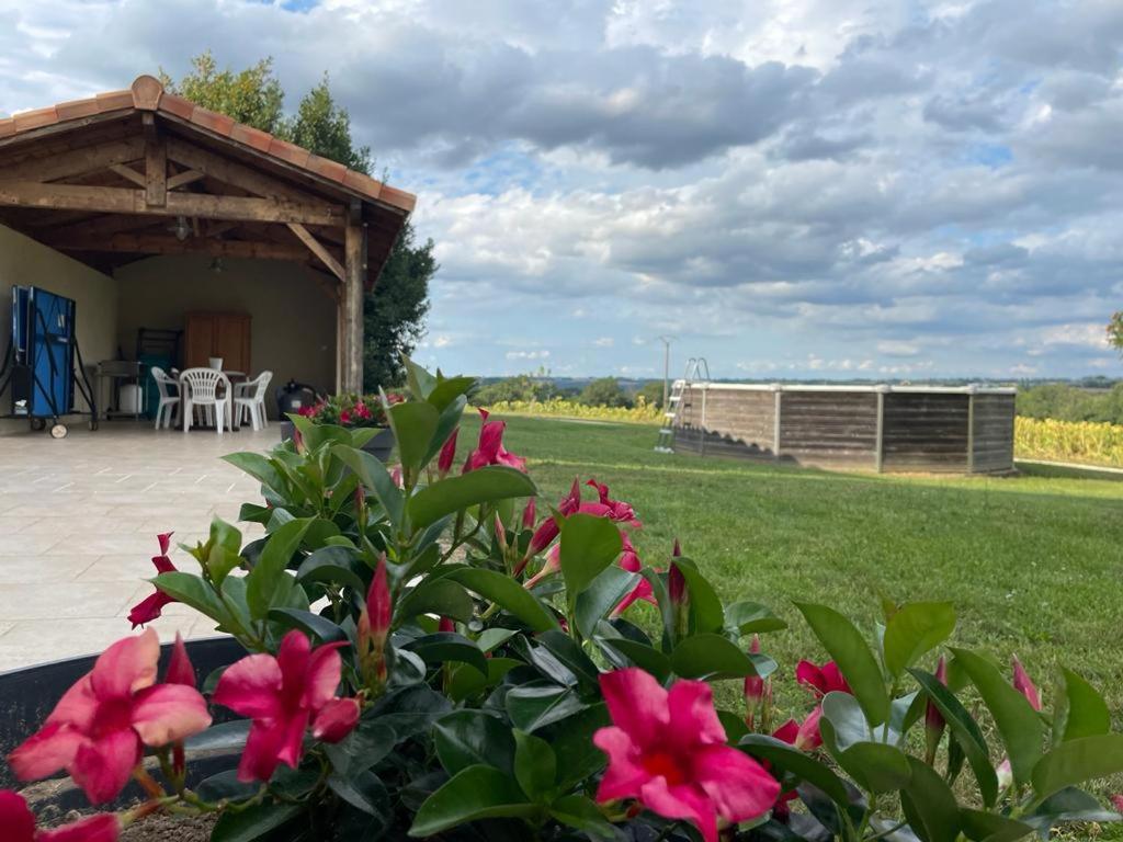 a garden with pink flowers and a pavilion at le Pigeonnier gersois in Condom