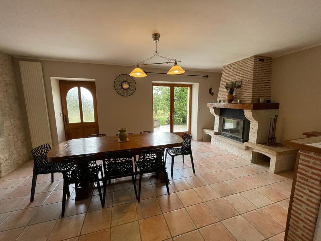 a dining room with a table and a fireplace at le Pigeonnier gersois in Condom