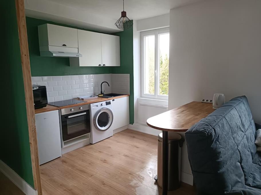 a kitchen with a washing machine and a table at Appartement Centre Ville in Nevers