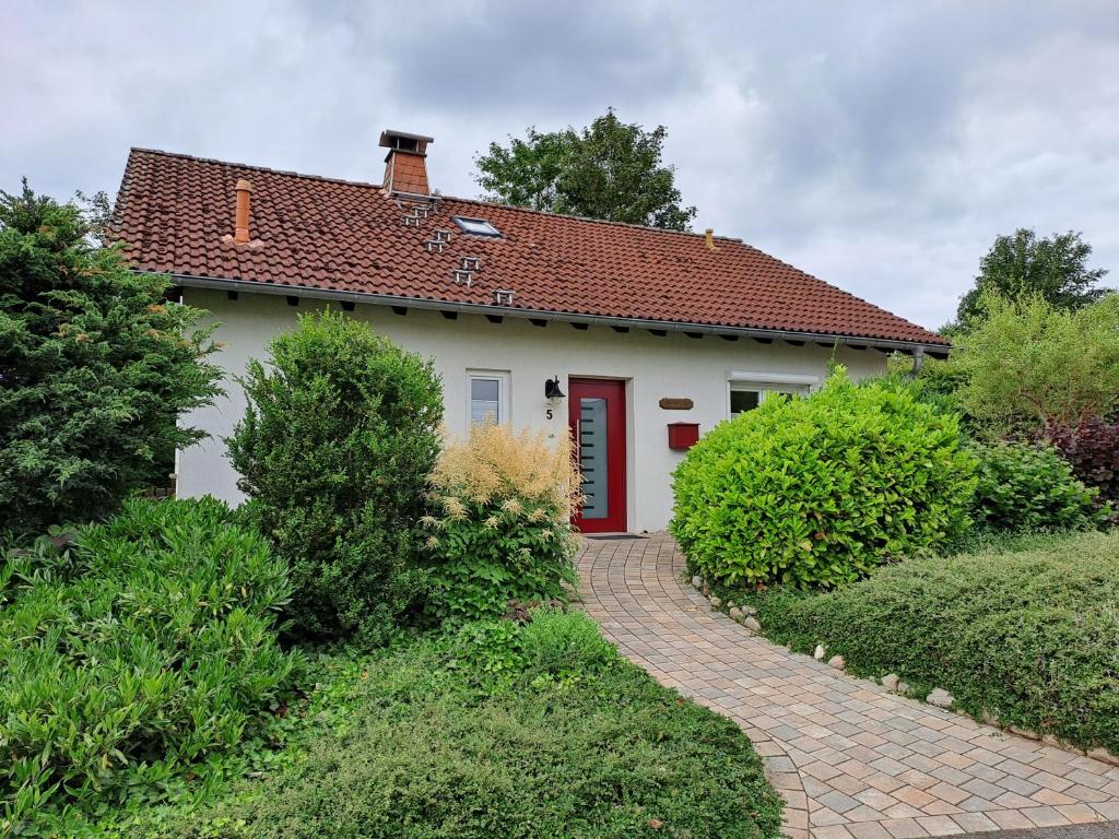 a white house with a red door and a walkway at Haus Sonnenburg in Dahlem