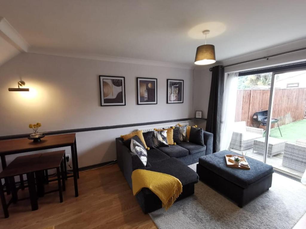 Suburban 2-bed, entire home, free parking, Maidstone, Kent UK في Boxley: غرفة معيشة مع أريكة وطاولة