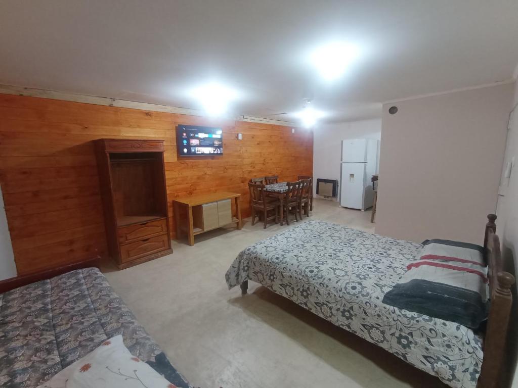 1 dormitorio con 2 camas y cocina con mesa en Ayre Sureño en Río Gallegos