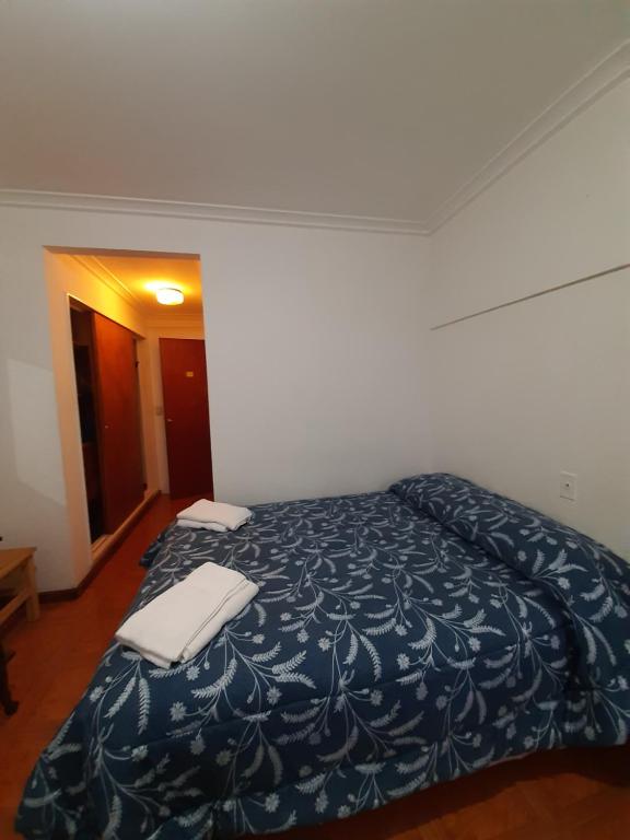 1 dormitorio con 1 cama con manta azul en Bariloche Natural en San Carlos de Bariloche