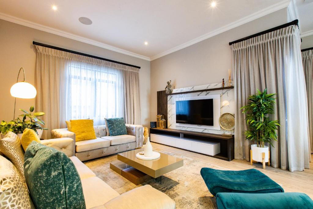 a living room with a couch and a tv at Eagle of Kawele 3-bedroom villa in Sandton