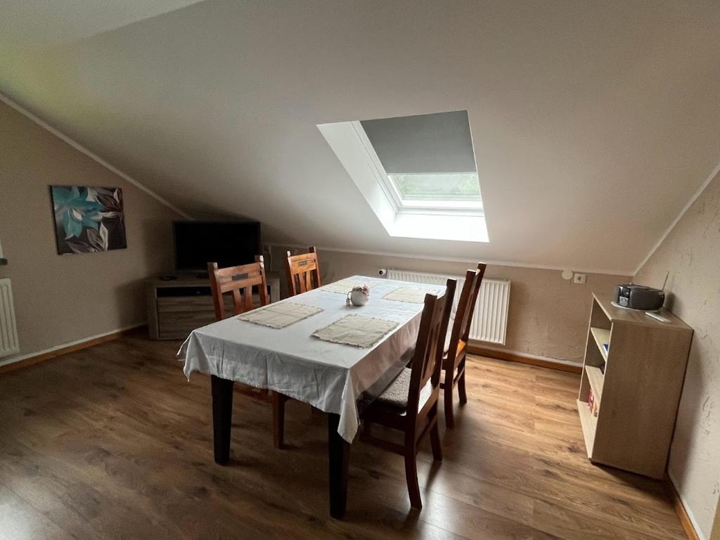 a dining room with a table and a skylight at Casa „Ella“ in Friedrichroda