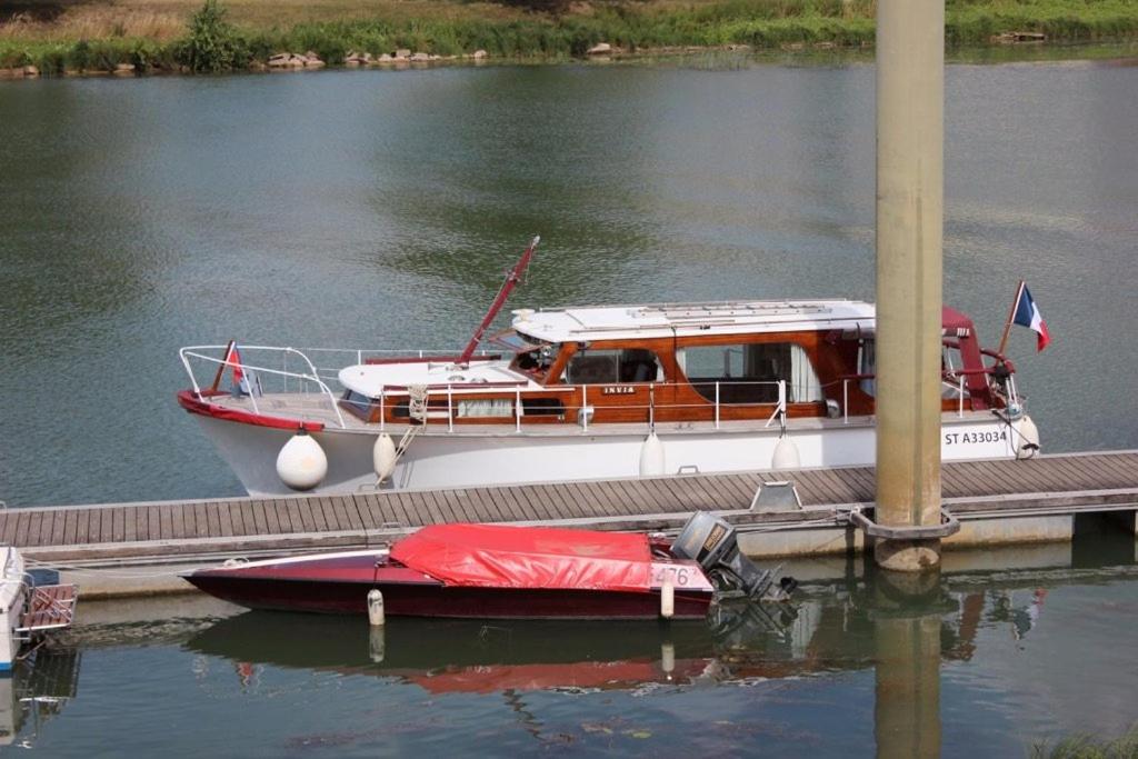 Un petit bateau est amarré à un quai. dans l'établissement Nuit insolite vedette "Pearce" Arles, à Arles