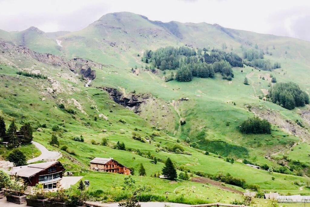 une colline verdoyante avec une maison au milieu dans l'établissement Beau F2 Idéalement situé, à Orcières