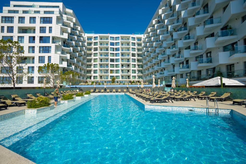 einem Pool vor einem großen Gebäude in der Unterkunft Anomis Infinity Pool & SPA Resort Sea-View in Mamaia Nord – Năvodari