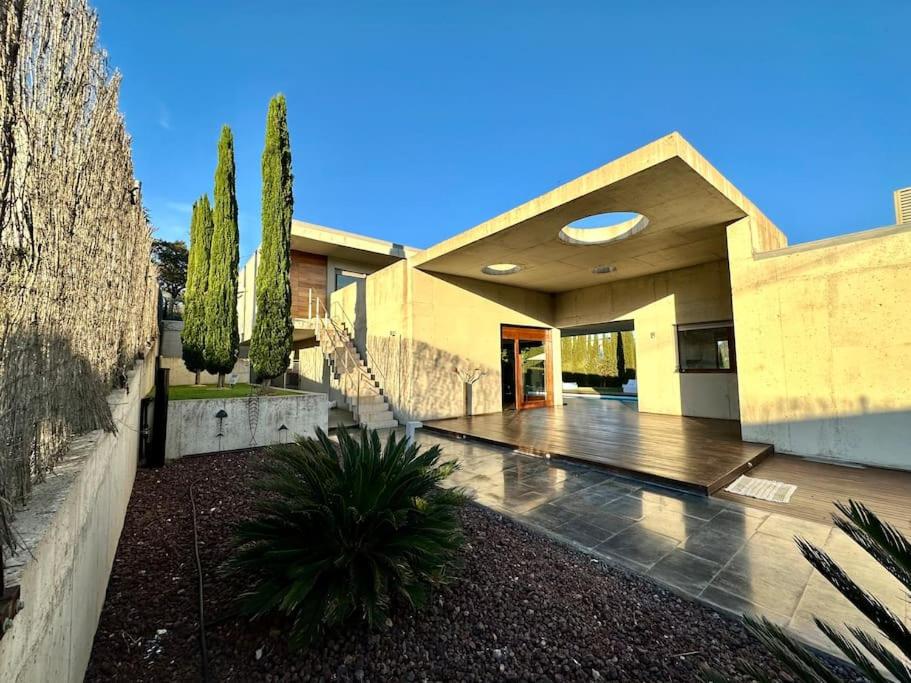 una grande casa con un portico con un frisbee di Villa Moderna Exclusiva con Jardín Privado La Villa de Sevilla a Guillena