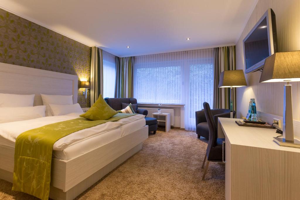 a hotel room with a bed and a desk at Hotel Garni Fürst von Waldeck in Willingen