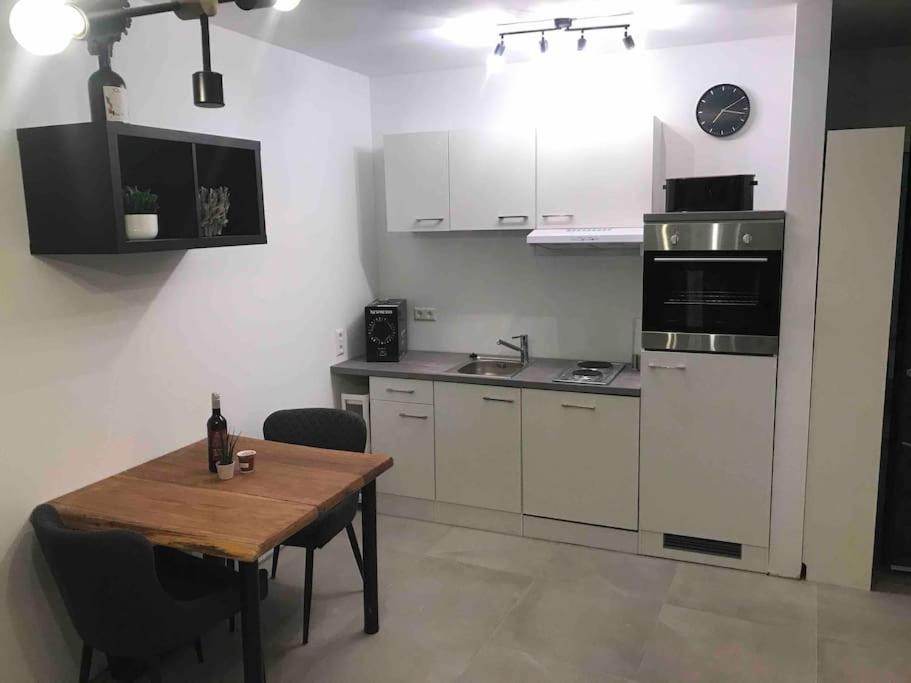 a kitchen with white cabinets and a wooden table at Apartment Bellalegna in Geislingen an der Steige
