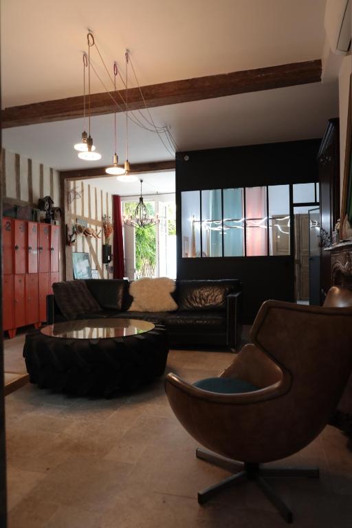 a living room with a couch and a table and chairs at Atelier des Glycines, Troyes Bouchon de Champagne, Sublime site patrimonial in Troyes