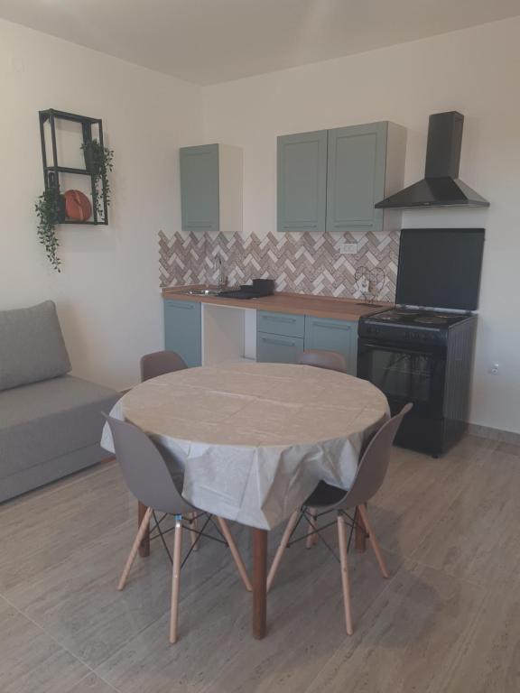 eine Küche mit einem Tisch und Stühlen im Zimmer in der Unterkunft Apartman Maša in Zadar