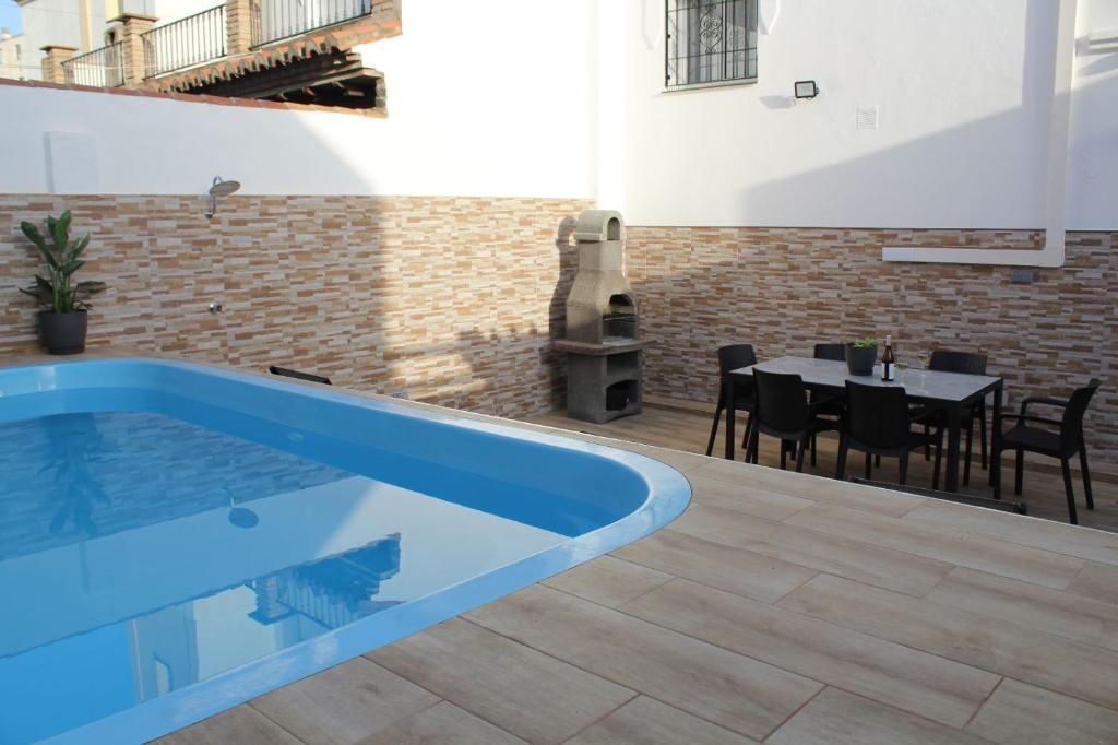 una piscina in una casa con tavolo e sedie di Villa Jara 25 a Nerja