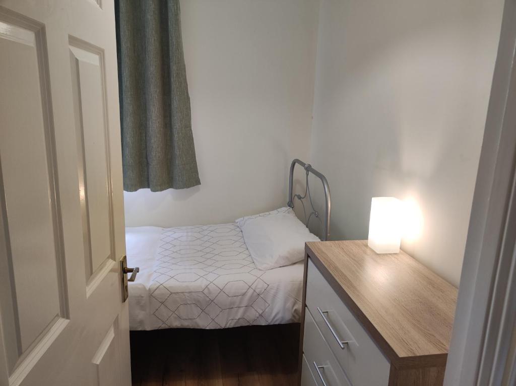 a small bedroom with a small bed and a lamp at Bluebell House in Newry