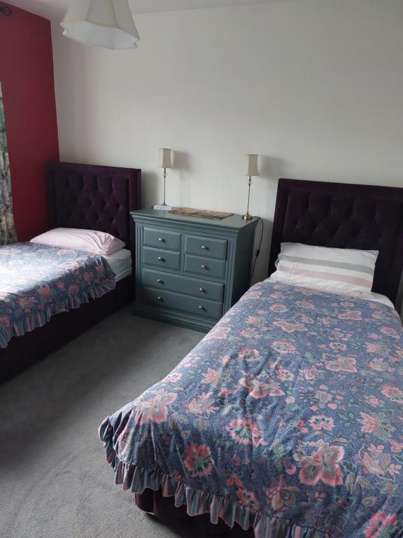 a bedroom with a bed and a dresser with a nightstand at Hillside Haven in Tipperary