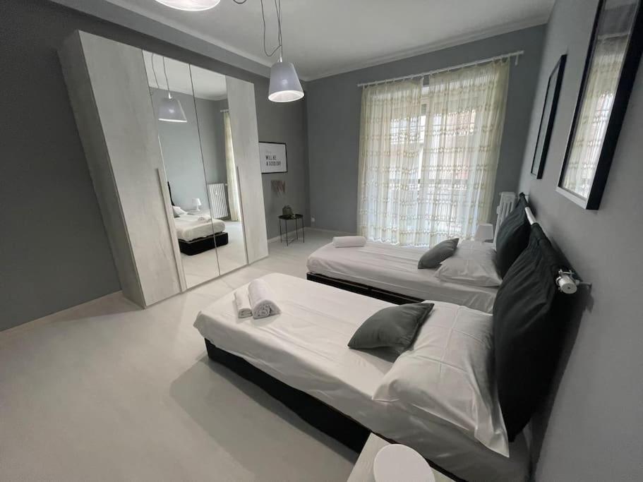 duża sypialnia z 2 łóżkami i lustrem w obiekcie Cozy Apartment x6 persone w Turynie