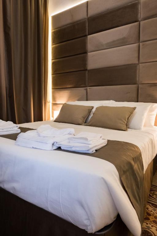 a bed with white sheets and towels on it at Caracciolo18 - GB in Naples