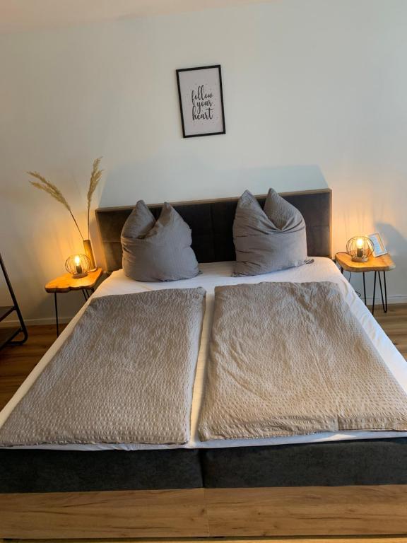 a large bed with two pillows on top of it at Staufen Herz NETFLIX WLAN in Oberstaufen
