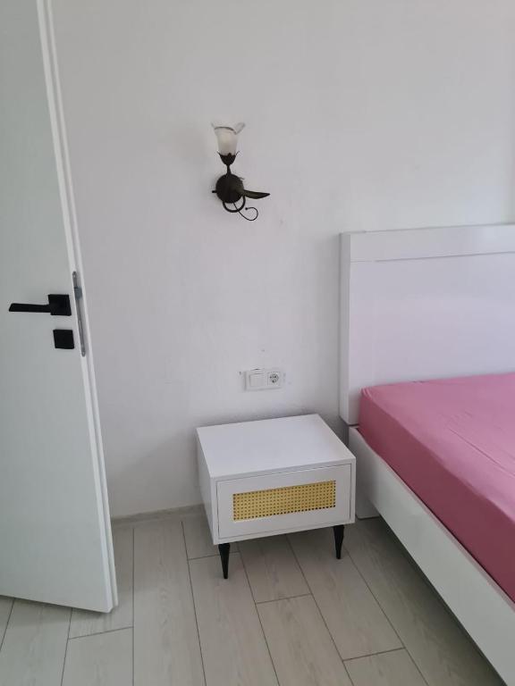 ein Schlafzimmer mit einem rosa Bett und einem Nachttisch in der Unterkunft 1922 Zeytin Apart in Demre