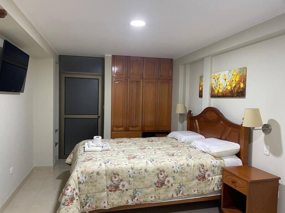 Schlafzimmer mit einem Bett und einem Holzschrank in der Unterkunft Hermoso minidepartamento in Huaraz