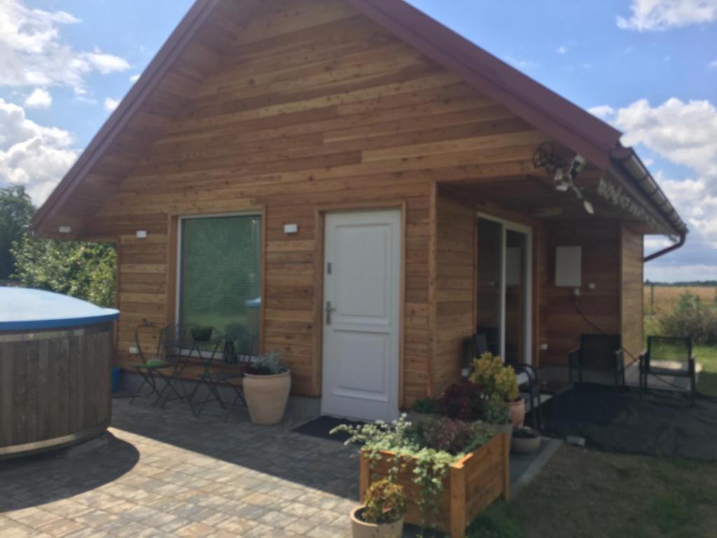 Cabaña de madera con puerta blanca y patio en Domek nad Bugiem z sauną, 