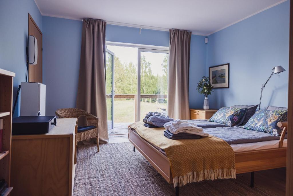 a bedroom with blue walls and a couch and a window at Susimetsa 