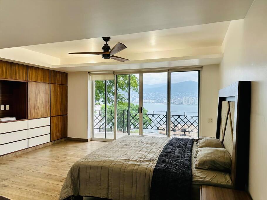 a bedroom with a bed and a view of the ocean at Vistas de Ensueño en Acapulco in Acapulco