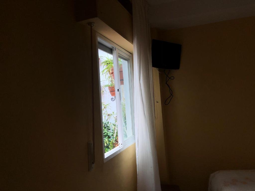 otwarte drzwi z oknem i telewizorem w obiekcie HOSTAL COSTA SOL w mieście Castell de Ferro