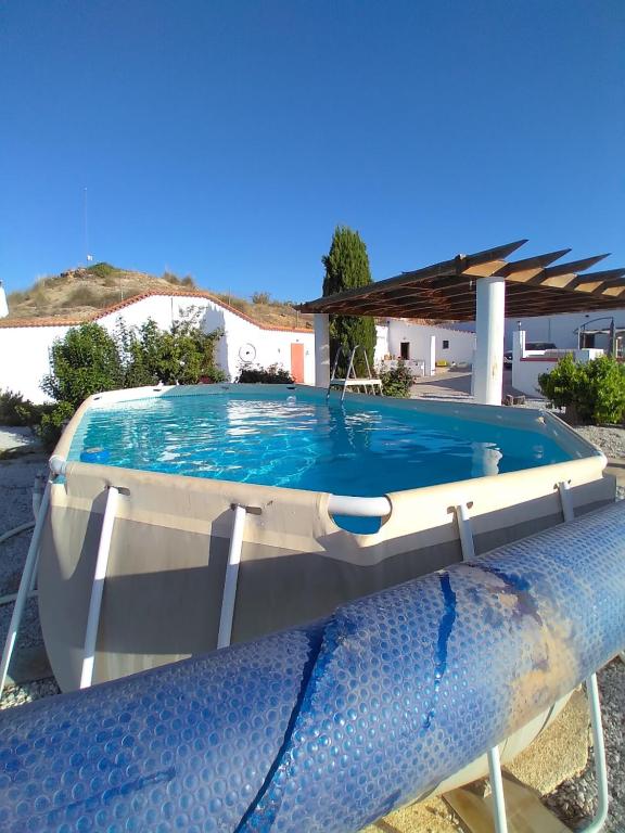 une grande piscine en face d'une maison dans l'établissement Cuevas Alia, à Castilléjar