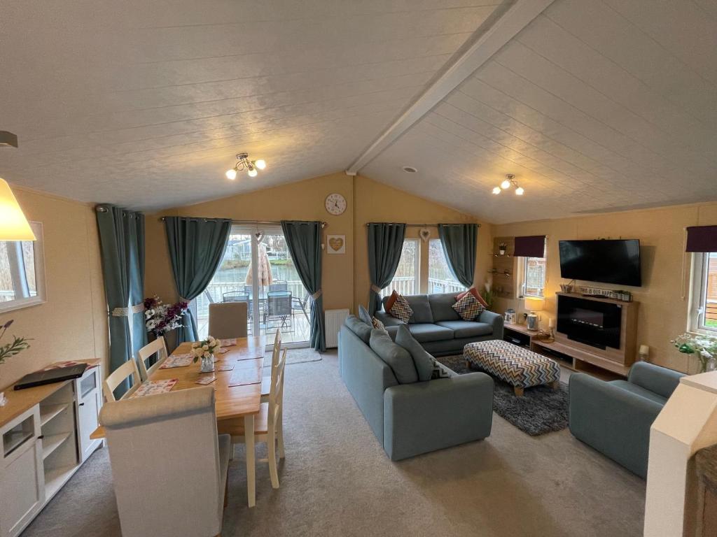 a living room with a couch and a table at Luxury Lakeside Lodge L2 with Hot tub situated at Tattershall Lakes Country Park in Tattershall