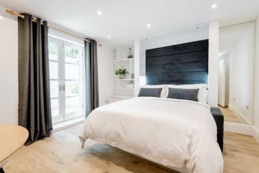 a bedroom with a large bed and a large window at Well-Positioned Studio Flat in London