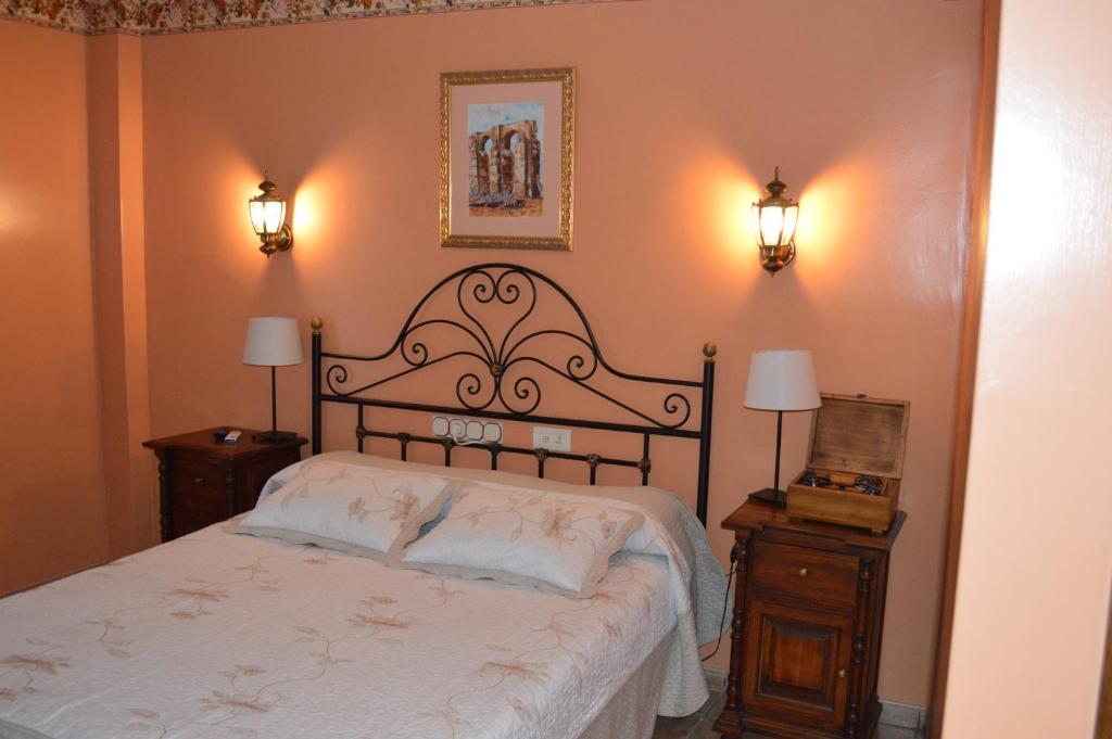 a bedroom with a large bed with two night stands at Hotel Don Javier in Ronda