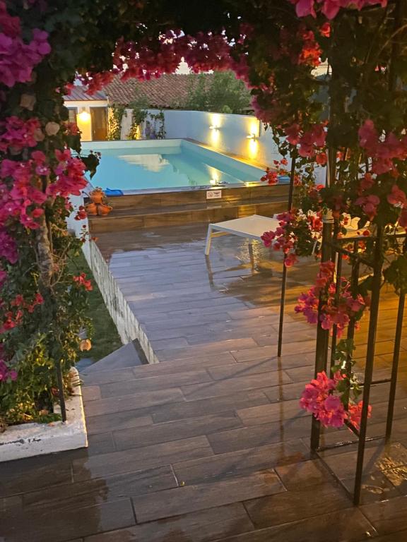 un patio trasero con piscina y flores en Buganvilla Alentejo en São Francisco da Serra