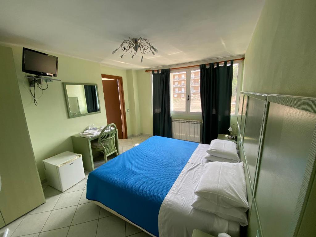 Un dormitorio con una cama azul y blanca y un escritorio en ATLAS en Serravalle Sesia