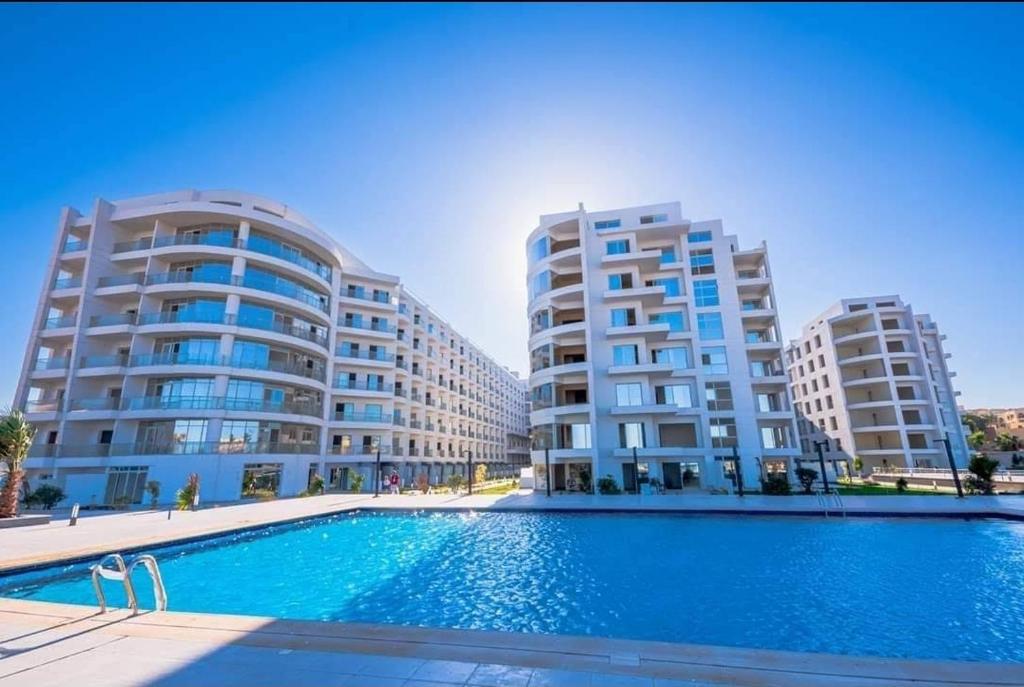 a swimming pool in front of two tall buildings at Scandic Resort Hurghada in Hurghada