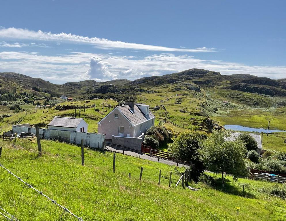 a farm in a grassy field with a house at 6 Calbost in Calbost