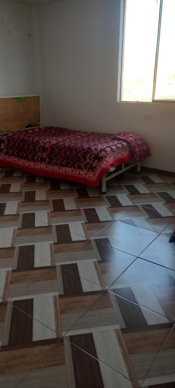een kamer met een bed op een tegelvloer bij Refugio de la felicidad in Huancayo
