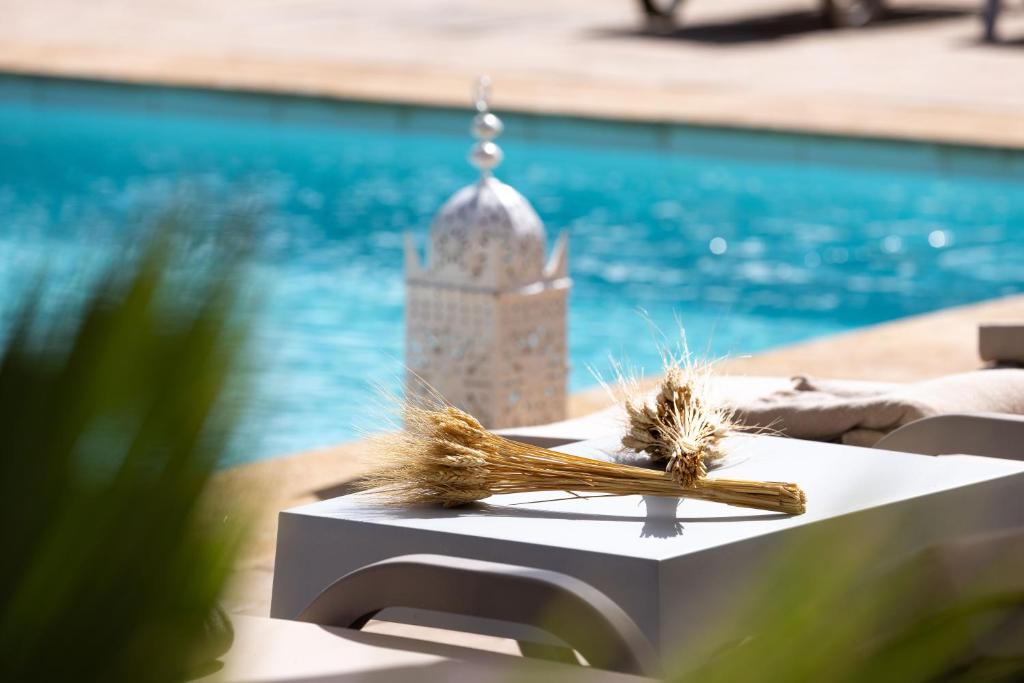 une table avec un modèle de mosquée à côté d'une piscine dans l'établissement Domaine Abiad, à Marrakech