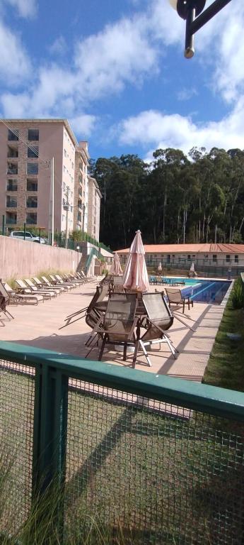 a row of tables and chairs next to a pool at Apto Cenário de Montanha in Araras Petropolis