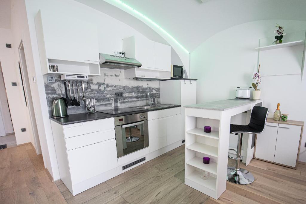 a white kitchen with a sink and a counter at Apartment MaRI&BoR in Maribor