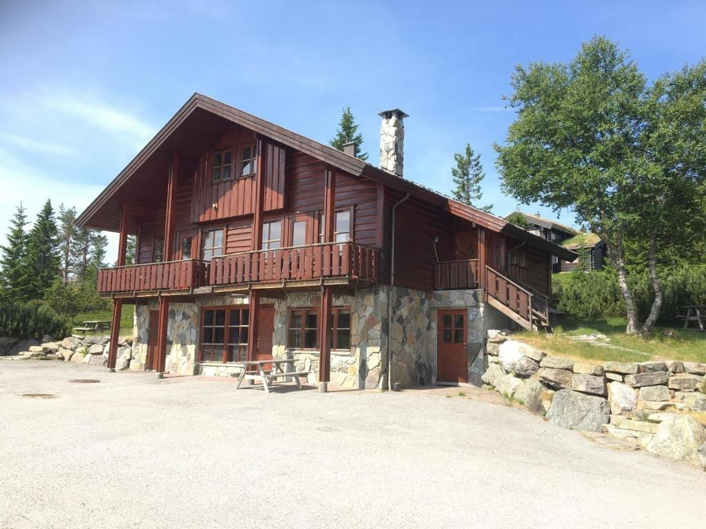 una gran casa de madera con una piedra en Trollbo ved Solstua en Lifjell