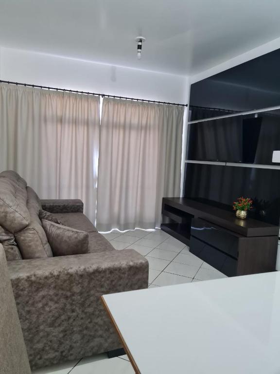 een woonkamer met een bank en een flatscreen-tv bij Apartamento com mobília nova 101! in Francisco Beltrão