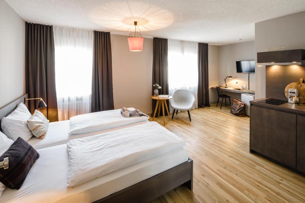 una camera d'albergo con un grande letto e una scrivania di Bold Hotel Frankfurt Messe a Francoforte sul Meno