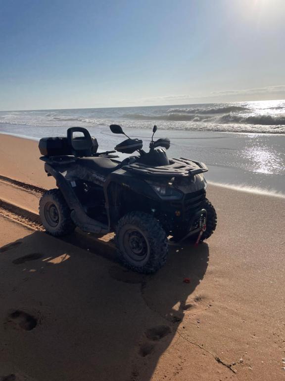 a atv parked on the beach near the ocean at Villa La Falaise in Oualidia