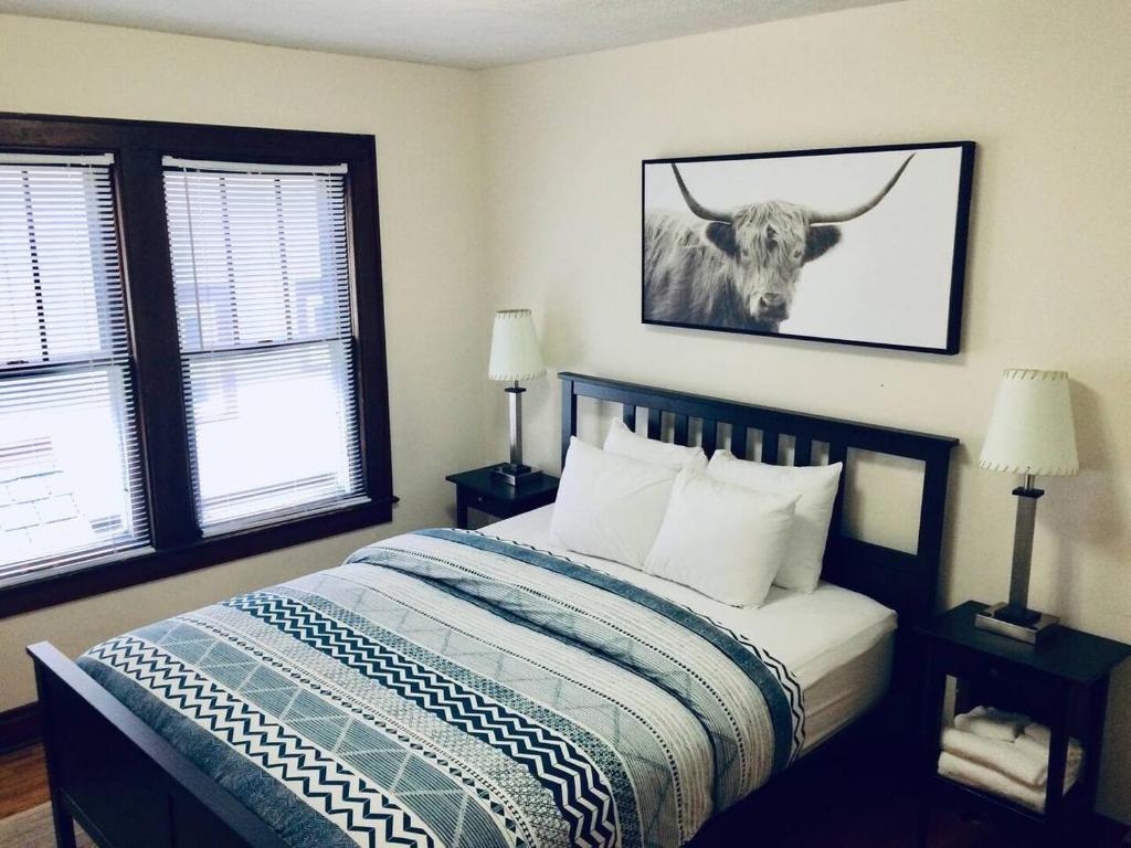 a bedroom with a bed with a bull picture on the wall at The House Hotels - New Crestview in Columbus