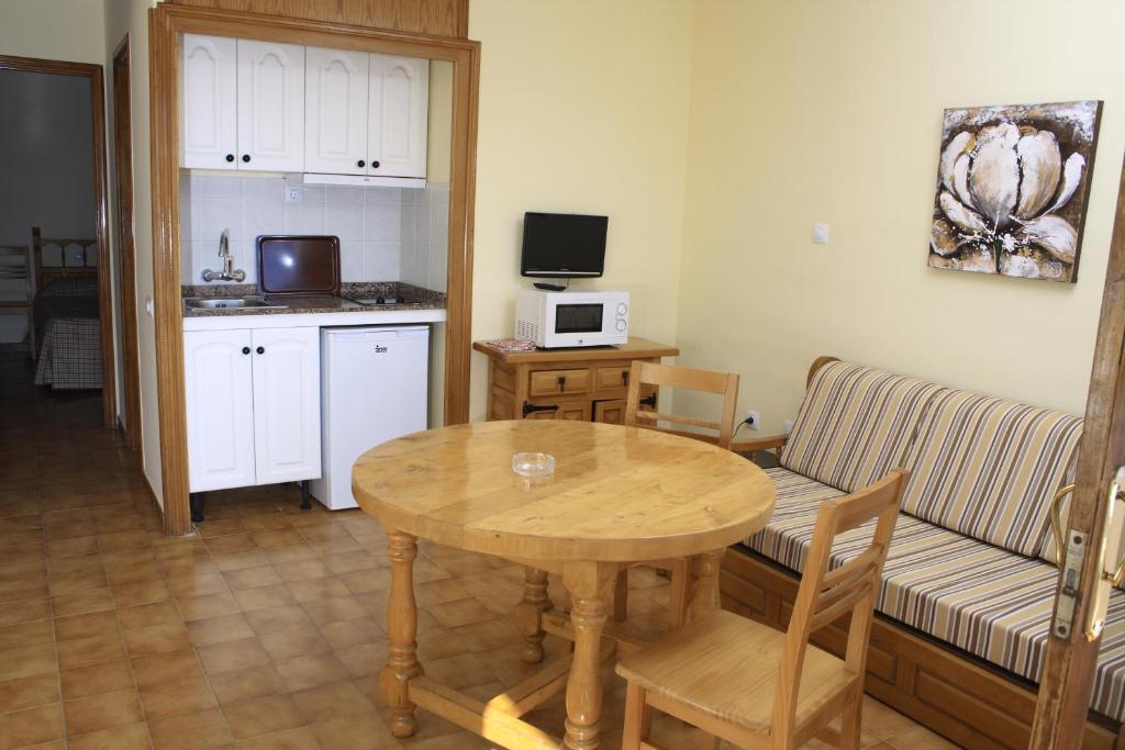 een woonkamer met een houten tafel en een keuken bij Apartamentos Tivoli in Playa del Inglés